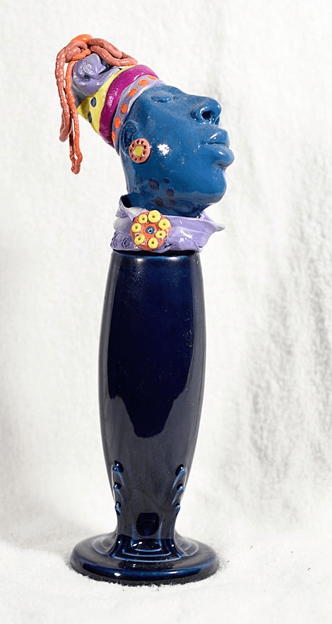 Blue head with colorful headress on blue pocelain base a Polymer Clay Sculpture    10.5 x 3 x 3  by artist Hollis Richardson